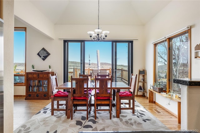 50 Deerwood Dr, Littleton, CO 80127 - dining area featuring wood finished floors, a chandelier, lofted ceiling, and plenty of natural light