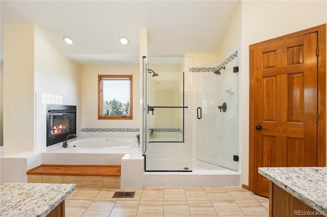 50 Deerwood Dr, Littleton, CO 80127 - bathroom featuring a stall shower, a bath, a tile fireplace, tile patterned floors, and vanity