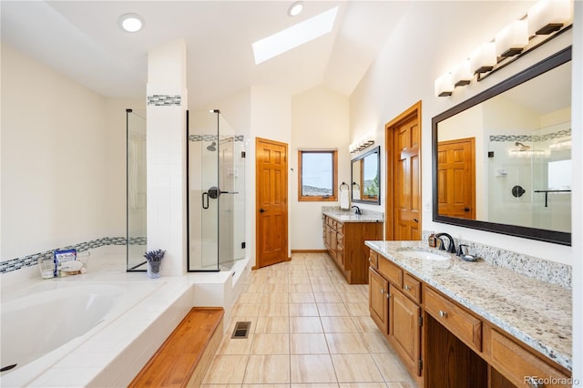 50 Deerwood Dr, Littleton, CO 80127 - full bath featuring a stall shower, a skylight, two vanities, a garden tub, and lofted ceiling