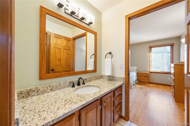 50 Deerwood Dr, Littleton, CO 80127 - ensuite bathroom with vanity, wood finished floors, and baseboards