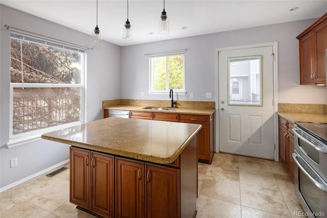 kitchen featuring a sink, stainless steel appliances, a center island, and brown cabinetry