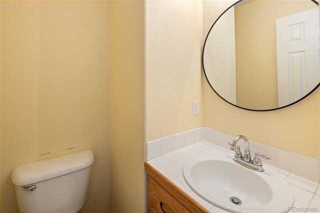 half bathroom featuring vanity and toilet