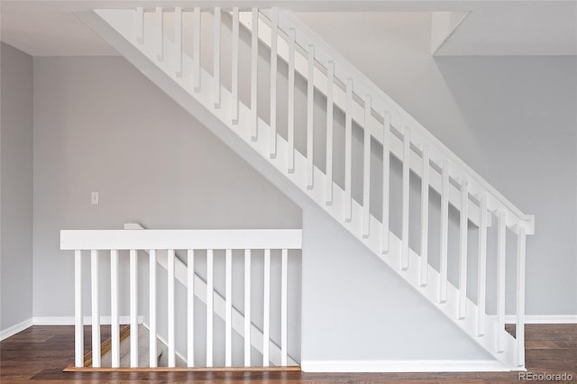stairway with wood finished floors and baseboards