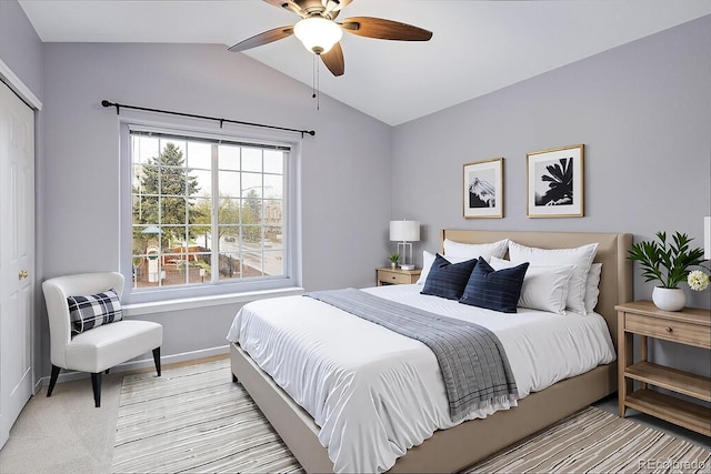 bedroom featuring lofted ceiling, baseboards, ceiling fan, and light colored carpet