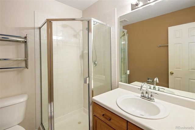 bathroom with a stall shower, toilet, and vanity