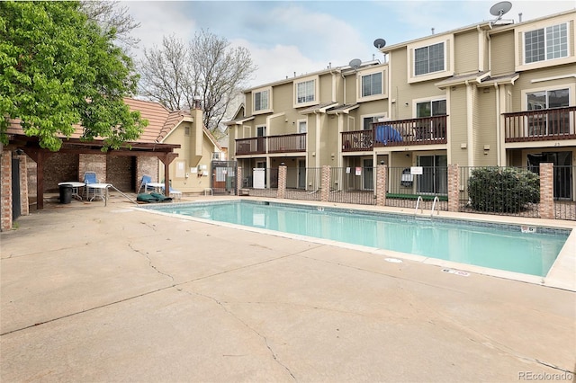community pool featuring fence and a patio