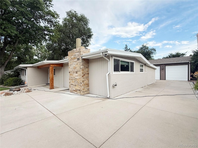 8930 W 55th Ave, Arvada, CO 80002 - view of front of property with a chimney, driveway, and an outbuilding