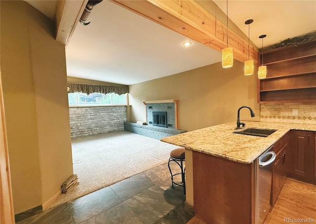 8930 W 55th Ave, Arvada, CO 80002 - kitchen featuring light stone countertops, open floor plan, hanging light fixtures, light colored carpet, and a fireplace with raised hearth