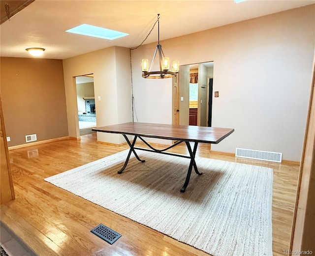 8930 W 55th Ave, Arvada, CO 80002 - unfurnished dining area featuring a skylight, wood finished floors, and a chandelier