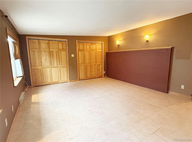 8930 W 55th Ave, Arvada, CO 80002 - unfurnished bedroom with two closets and light tile patterned flooring
