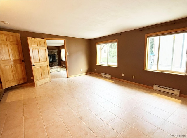 8930 W 55th Ave, Arvada, CO 80002 - unfurnished room with a baseboard radiator, plenty of natural light, and a fireplace
