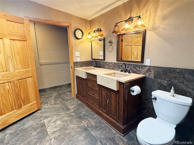8930 W 55th Ave, Arvada, CO 80002 - full bathroom featuring wainscoting, double vanity, and tile walls