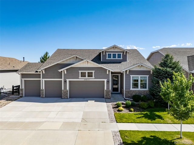 23615 E Del Norte Pl, Aurora, CO 80016 - craftsman-style house featuring roof with shingles, stone siding, concrete driveway, a front yard, and an attached garage
