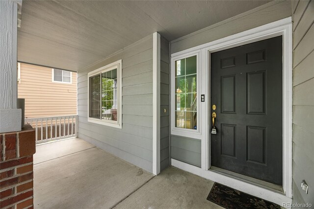 18121 E Adriatic, Aurora, CO 80013 - doorway to property featuring covered porch
