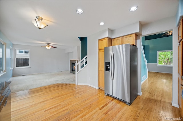 18121 E Adriatic, Aurora, CO 80013 - kitchen featuring stainless steel fridge with ice dispenser, a ceiling fan, light wood-style floors, a glass covered fireplace, and open floor plan