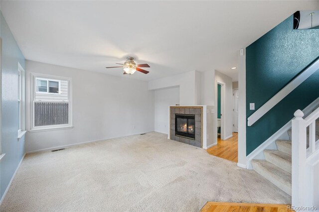 18121 E Adriatic, Aurora, CO 80013 - unfurnished living room featuring carpet flooring, ceiling fan, stairs, baseboards, and a fireplace