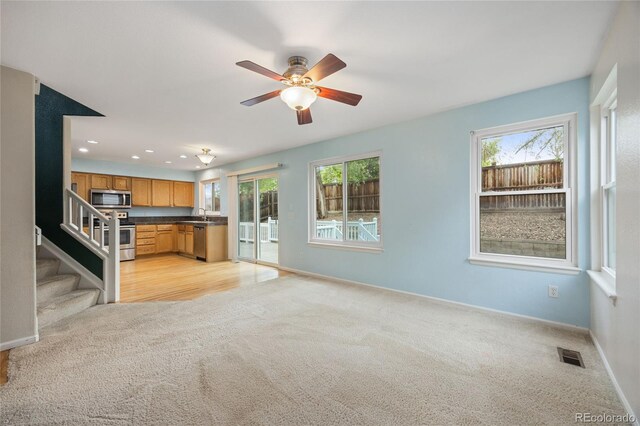 18121 E Adriatic, Aurora, CO 80013 - unfurnished living room with light colored carpet, healthy amount of natural light, baseboards, a ceiling fan, and recessed lighting