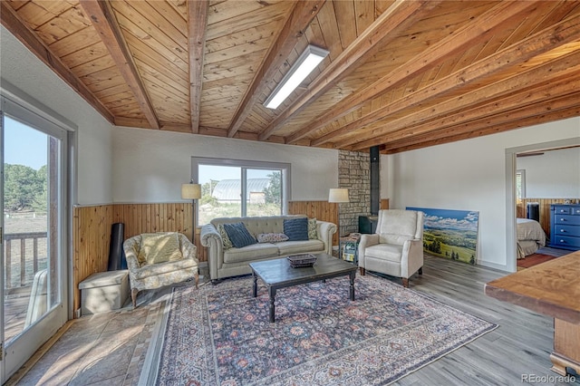 living room with brick wall, wood ceiling, a wood stove, hardwood / wood-style floors, and lofted ceiling with beams