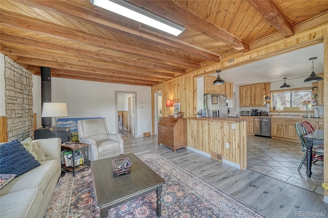 living room featuring wooden ceiling, beam ceiling, light hardwood / wood-style flooring, and a wood stove