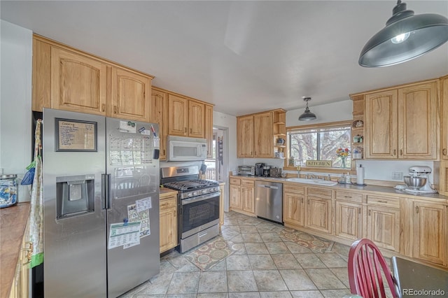 kitchen with sink, light brown cabinetry, appliances with stainless steel finishes, and light tile patterned floors