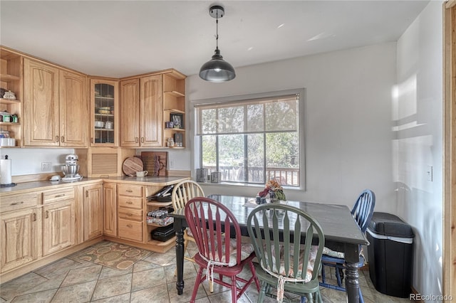 kitchen featuring light brown cabinets, hanging light fixtures, and light tile patterned floors