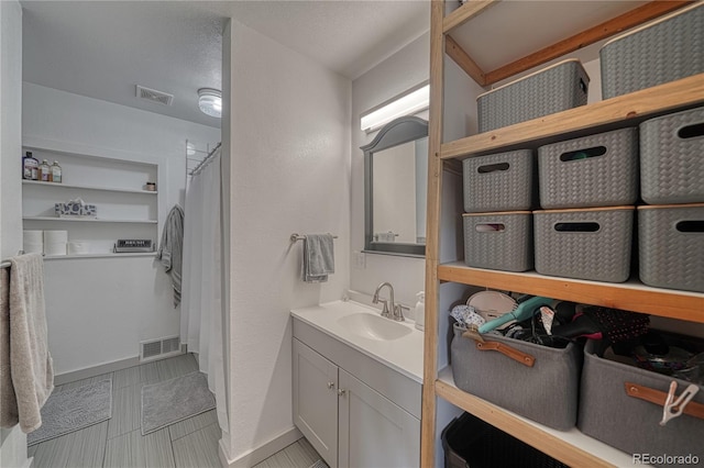 bathroom featuring tile patterned flooring, vanity, and curtained shower