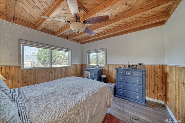 bedroom with beamed ceiling, hardwood / wood-style flooring, wood ceiling, and ceiling fan