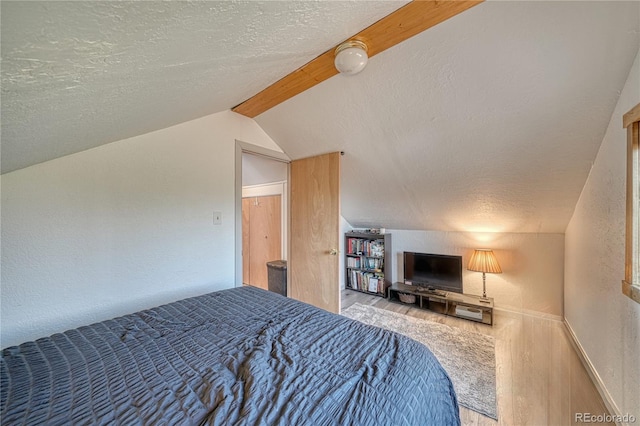 bedroom with a textured ceiling and lofted ceiling