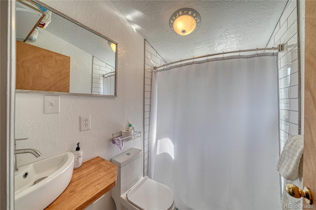 bathroom with a textured ceiling, vanity, a shower with curtain, and toilet