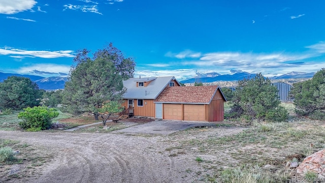 view of property exterior with a mountain view and a garage