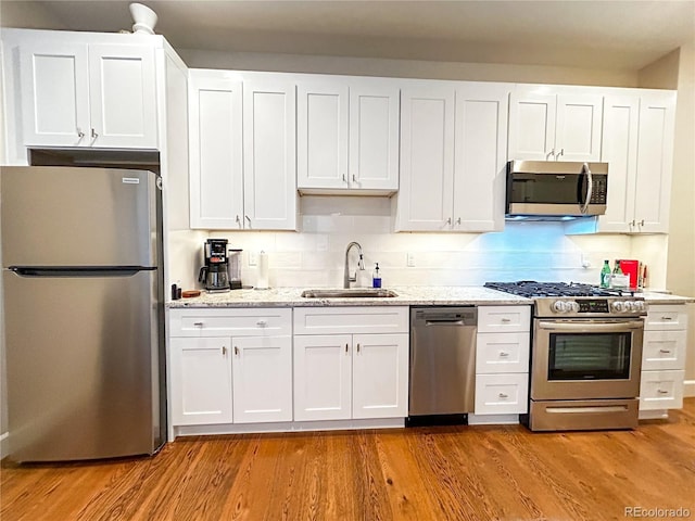 824 Grand Ave Unit 110, Grand Lake, CO 80447 - kitchen with appliances with stainless steel finishes, a sink, white cabinets, and wood finished floors