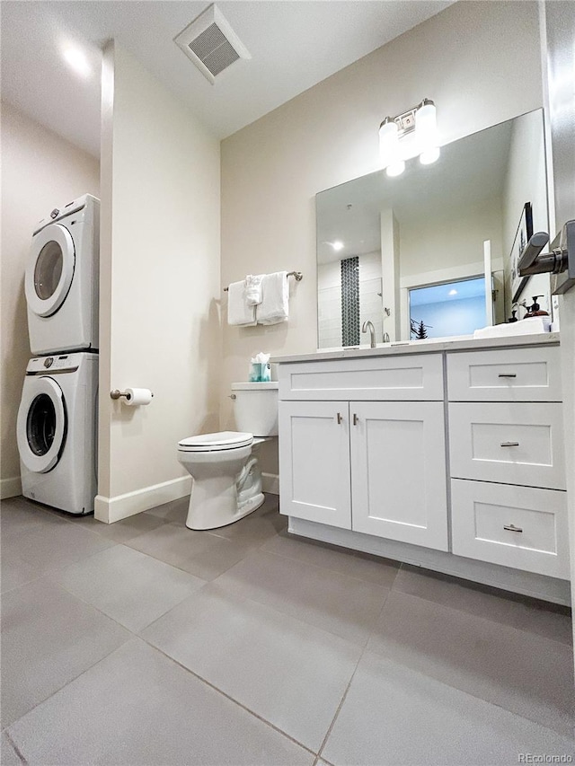 824 Grand Ave Unit 110, Grand Lake, CO 80447 - bathroom featuring stacked washer / dryer, baseboards, toilet, tile patterned flooring, and vanity