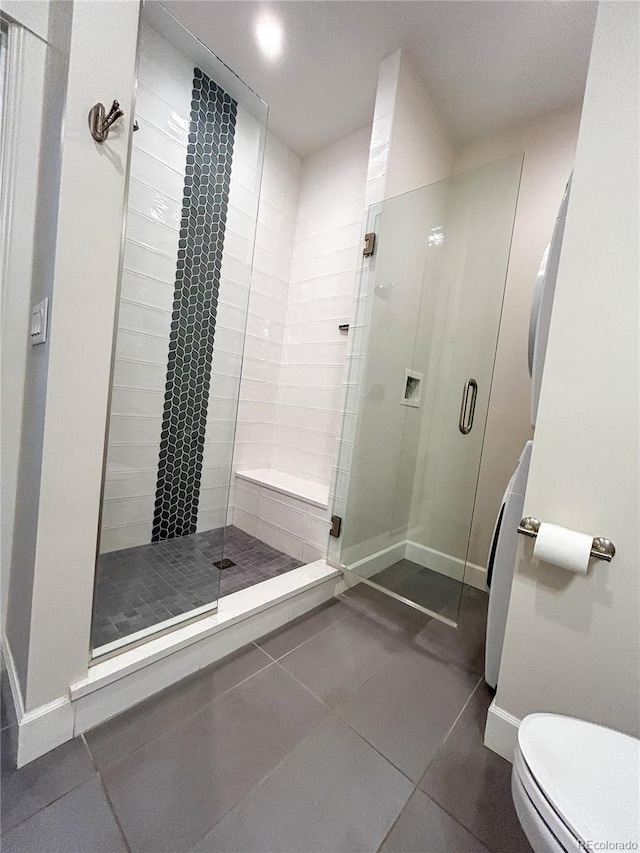 824 Grand Ave Unit 110, Grand Lake, CO 80447 - bathroom with tile patterned flooring, a shower stall, toilet, and baseboards