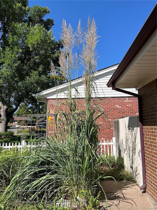 exterior space featuring brick siding and fence