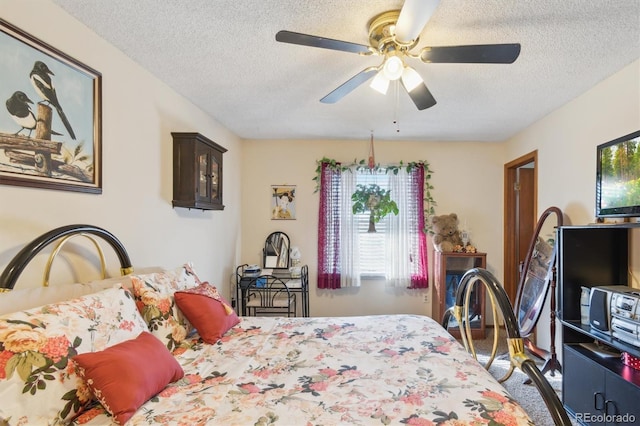 bedroom with ceiling fan and a textured ceiling