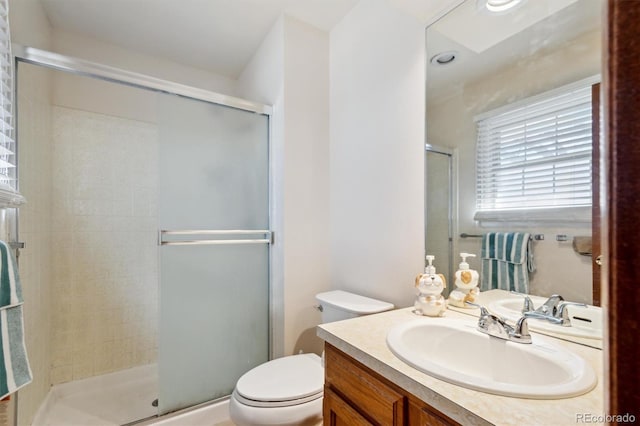 bathroom featuring a shower stall, toilet, and vanity