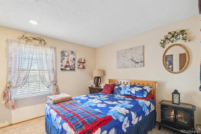 bedroom with carpet floors, baseboards, and a textured ceiling