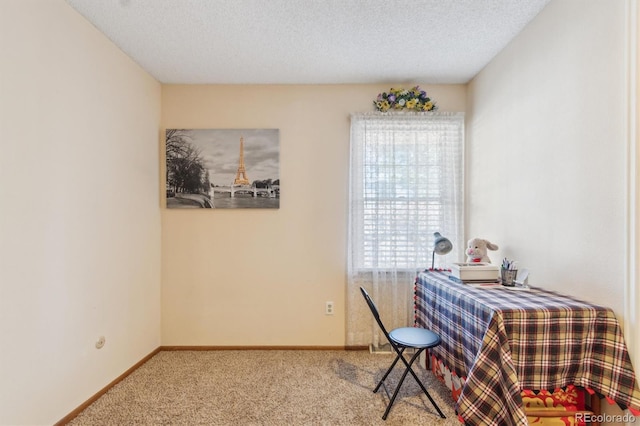 carpeted dining room featuring a textured ceiling and baseboards