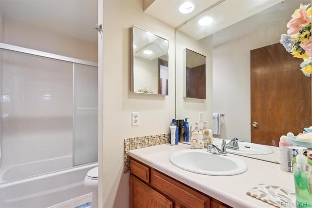 bathroom with combined bath / shower with glass door, vanity, and toilet