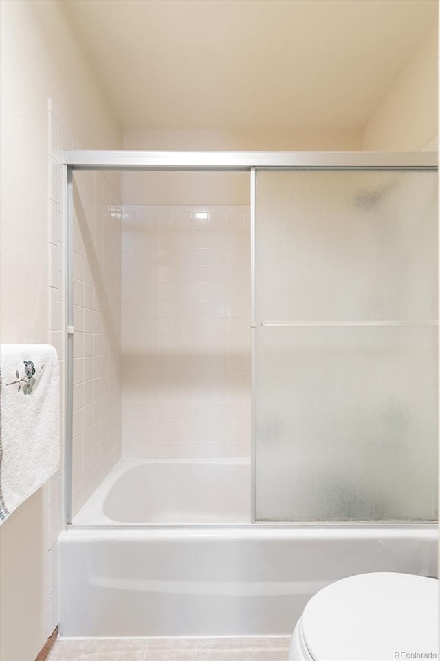 full bath with shower / bath combination with glass door and toilet