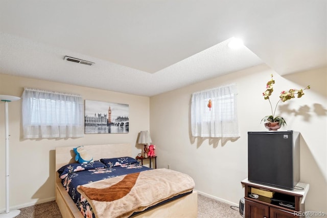 carpeted bedroom with visible vents and baseboards