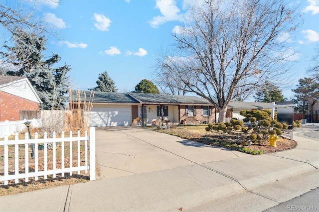 ranch-style house with driveway, an attached garage, and fence