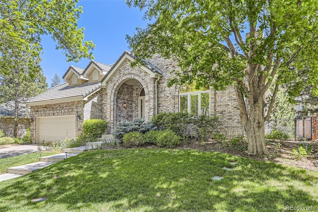 85 Silver Fox Dr, Greenwood Village, CO 80121 - view of front facade featuring an attached garage, driveway, a tile roof, stone siding, and brick siding