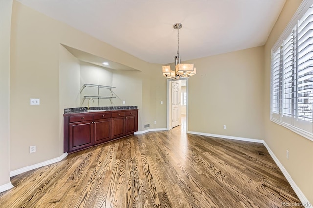 85 Silver Fox Dr, Greenwood Village, CO 80121 - empty room featuring a sink, light wood-type flooring, a chandelier, and baseboards
