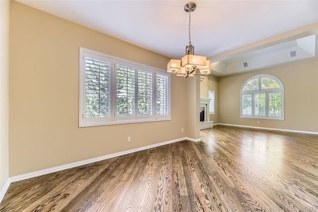 85 Silver Fox Dr, Greenwood Village, CO 80121 - unfurnished room with a chandelier, wood finished floors, baseboards, and a fireplace with raised hearth