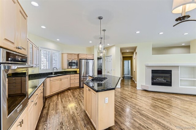 85 Silver Fox Dr, Greenwood Village, CO 80121 - kitchen featuring appliances with stainless steel finishes, light brown cabinets, light wood-style flooring, a kitchen island, and a sink