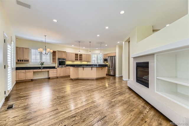 85 Silver Fox Dr, Greenwood Village, CO 80121 - kitchen with stainless steel appliances, dark countertops, recessed lighting, a kitchen breakfast bar, and wood finished floors