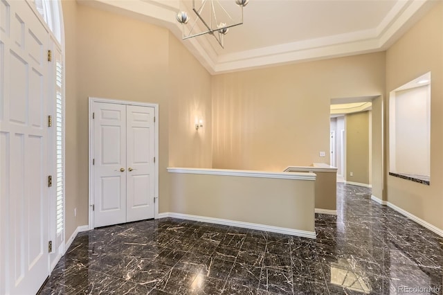 85 Silver Fox Dr, Greenwood Village, CO 80121 - unfurnished room with a towering ceiling, a chandelier, baseboards, plenty of natural light, and marble finish flooring