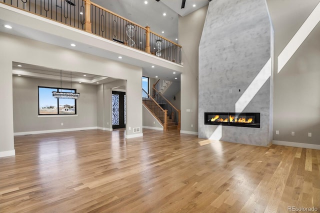 16250 Kenosha St, Brighton, CO 80603 - unfurnished living room with wood finished floors, baseboards, recessed lighting, a high end fireplace, and stairs