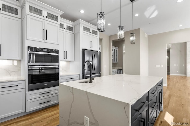16250 Kenosha St, Brighton, CO 80603 - kitchen featuring visible vents, an island with sink, dobule oven black, decorative light fixtures, and stainless steel fridge